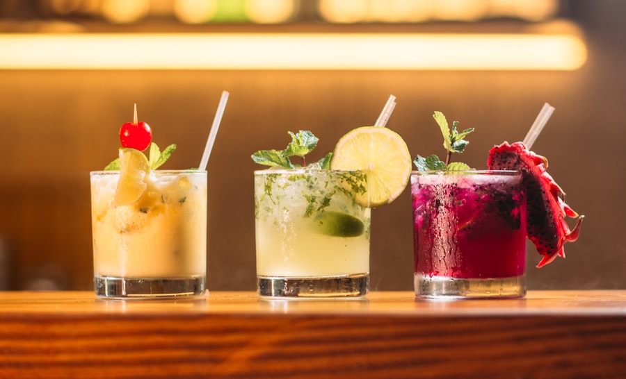 Three colorful cocktails on a wood bar
